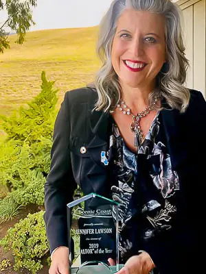 Real Estate RE/MAX® Broker Associate Jennifer Lawson holding Central Coast Real Estate Realtor® of the Year award.